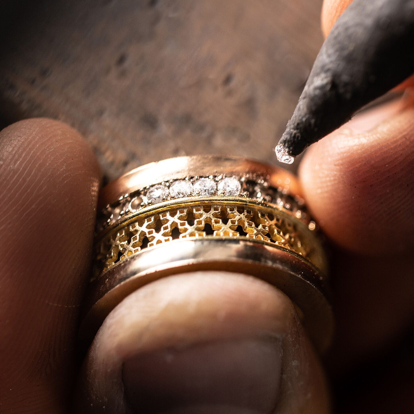 A a jeweller placing a diamond in a Birks Dare to Dream ring setting.